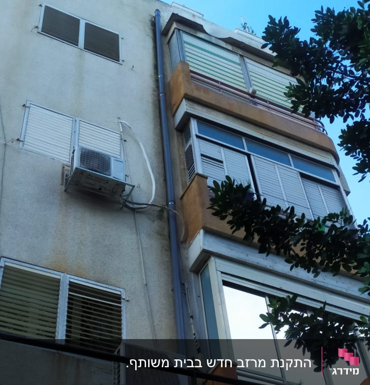 גג בניין עם צינור ניקוז ומזגנים